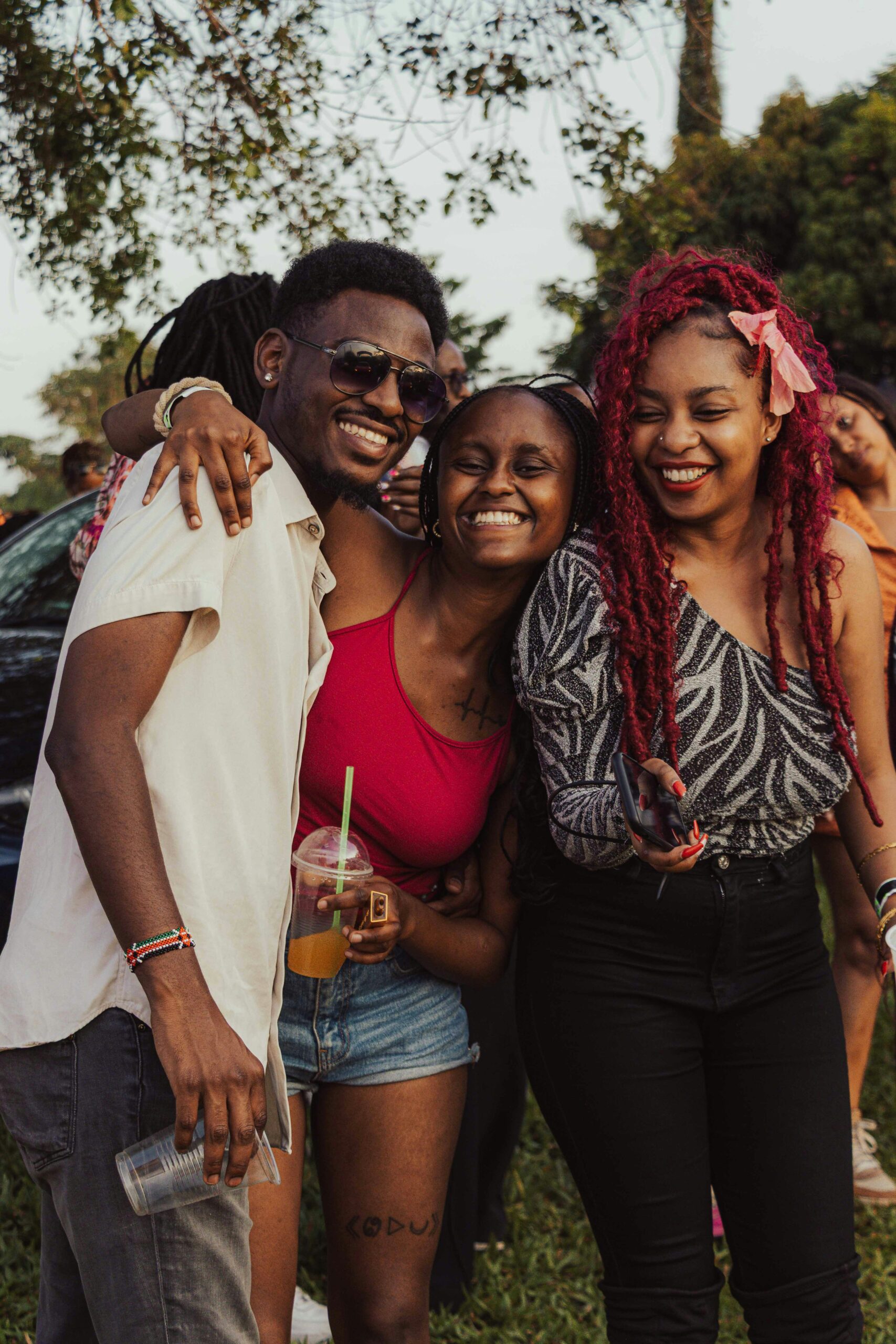 Black friends smiling together at an outdoor community gathering